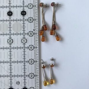 2 pairs of silver and amber colored earrings